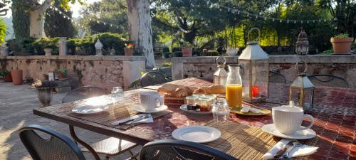 - une table en bois avec de la nourriture et des boissons dans l'établissement Chambre d'Hotes Lamanon, avec ou sans petit déjeuner - Domaine Les Peupliers -, à Lagnes