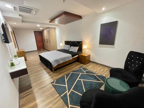 AirReside Hotel Apartments Gold Crest في لاهور: غرفة نوم مع سرير وغرفة معيشة