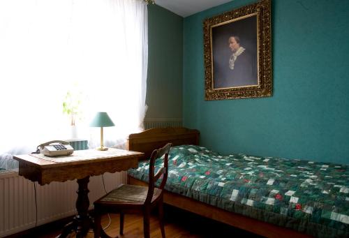 a bedroom with a bed and a table with a picture on the wall at Hotel Reingard in Wismar