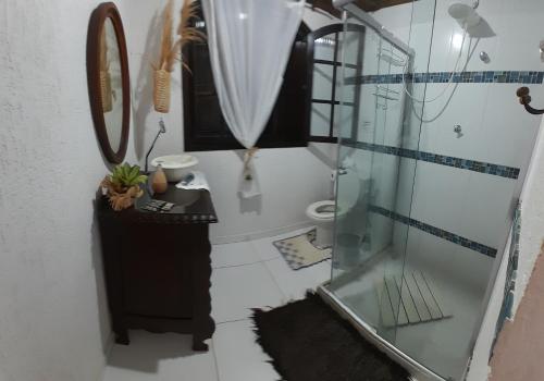 uma casa de banho com uma cabina de duche em vidro e um lavatório. em Suite Privativa Lar e Aconhego em Maricá