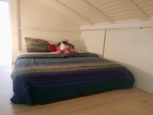 a stuffed animal sitting on top of a bed in a room at Cheerful villa with fireplace, bath-tub and garden in Noville