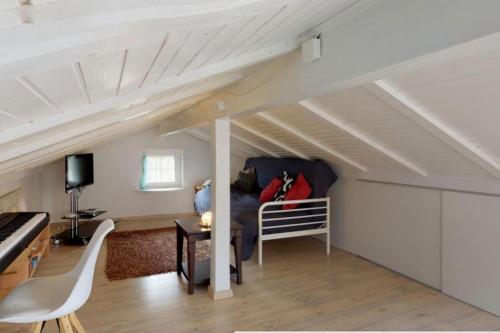 a living room with a couch and a piano at Cheerful villa with fireplace, bath-tub and garden in Noville