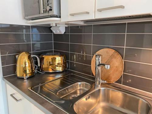um balcão de cozinha com um lavatório e duas torradeiras em Beautiful apartment - own parking space included em Vantaa