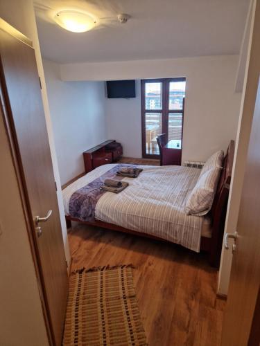 a small bedroom with a bed and a window at Mountain View Resort - Apartment B45 in Bansko