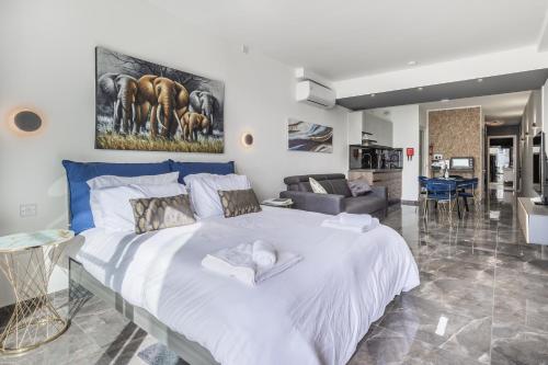 a bedroom with a large white bed and a living room at Spinola Studio Deluxe, StJulians in St. Julianʼs