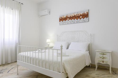 a white bedroom with a white bed and a table at La Gemma del Salento Rooms&Apartments in Racale
