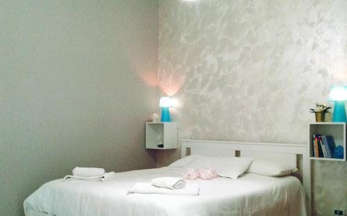 a bedroom with a white bed with two towels on it at La Gemma del Salento Rooms&Apartments in Racale