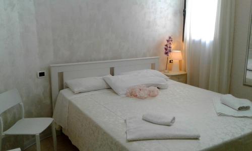 a bedroom with a white bed with towels on it at La Gemma del Salento Rooms&Apartments in Racale