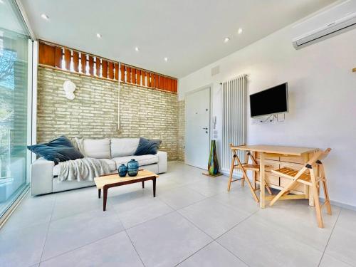 una sala de estar con un sofá y una mesa en Filzi-Flexrent Immobiliare Abissinia, en Riccione