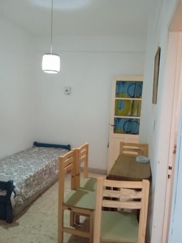 Habitación con cama, mesa y sillas. en La perla en Mar del Plata