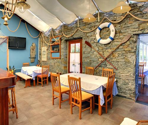 a dining room with tables and chairs and a stone wall at Villa La Argentina in Luarca