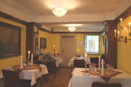 a dining room with tables and chairs and a chandelier at Hotel Reingard in Wismar