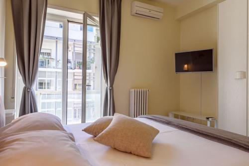 a bedroom with a bed with a tv and a window at Centralflats 195 in Bari