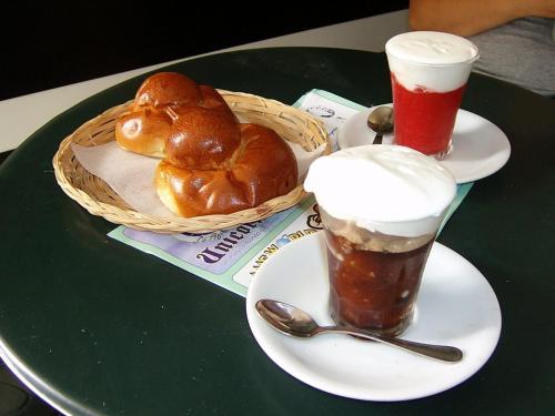 a table with two plates of bread and two drinks at Malù Suites in Messina