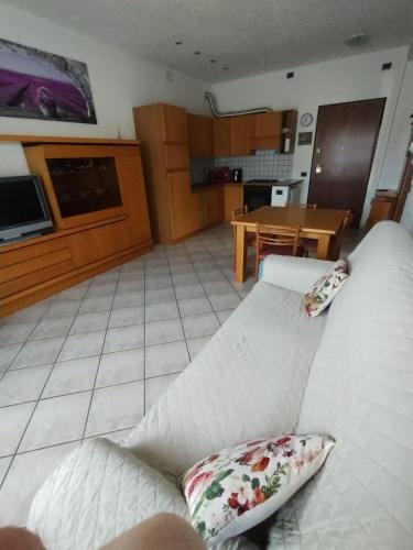 een woonkamer met een witte bank en een keuken bij Casa Maria in Saint-Pierre
