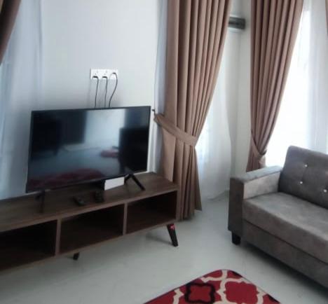 a living room with a flat screen tv and a couch at Homestay Cikgu Alif in Wakaf Baharu