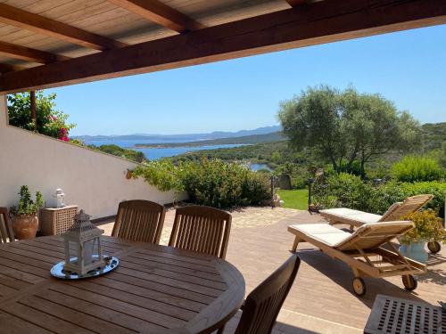 a wooden table and chairs on a patio at Villa Erica a Valle Dell Erica in Valle Dell’Erica