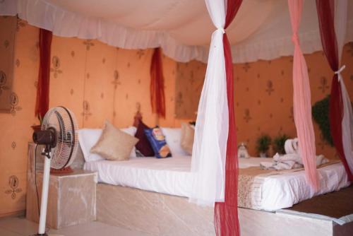 a bedroom with two beds and a fan at Uma Aangan Resort in Sām
