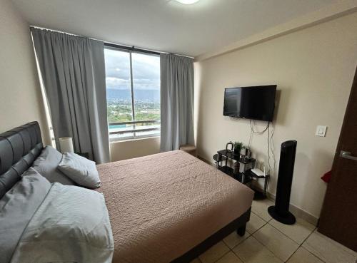 - une chambre avec un lit et une grande fenêtre dans l'établissement Lindo apartamento en condominio privado, 