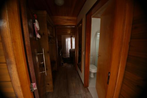 a hallway to a bathroom with a toilet in a room at Pousada Vila dos Butias in Urubici