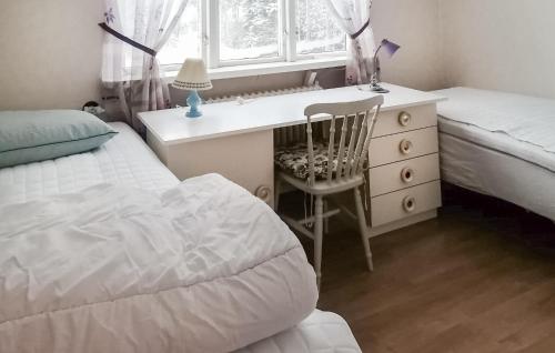 a bedroom with a desk and a bed and a chair at Nice Home In Ambjörnarp With Lake View in Ambjörnarp
