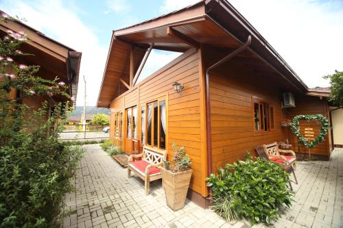 a small wooden house with a patio and some plants at Pousada Vila dos Butias in Urubici