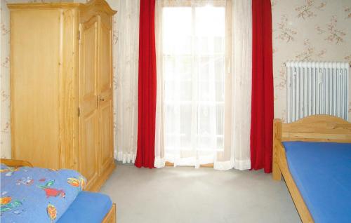 a bedroom with a bed and a window with red curtains at Nice Apartment In Ehrwald With 2 Bedrooms And Wifi in Ehrwald