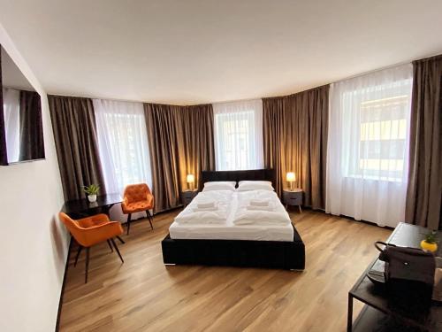 ein großes Schlafzimmer mit einem Bett und einem Stuhl in der Unterkunft Hotel Elisei in Nürnberg