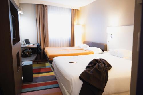 a hotel room with two beds and a television at ibis Styles Lyon Sud Vienne in Chasse-sur-Rhône