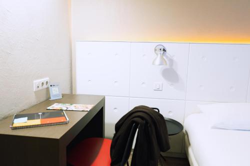 a bedroom with a desk and a bed and a table at ibis Styles Lyon Sud Vienne in Chasse-sur-Rhône