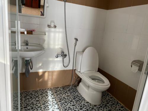 ein Bad mit einem WC und einem Waschbecken in der Unterkunft Khách sạn Ngọc Hồi 2 in Buôn Kô Sir