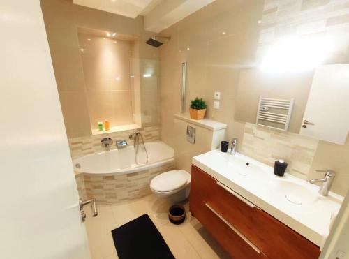 une salle de bain avec une baignoire, des toilettes et un lavabo dans l'établissement DisneyLand - Paris 20 min - Parking - 7 personnes, à Gournay-sur-Marne