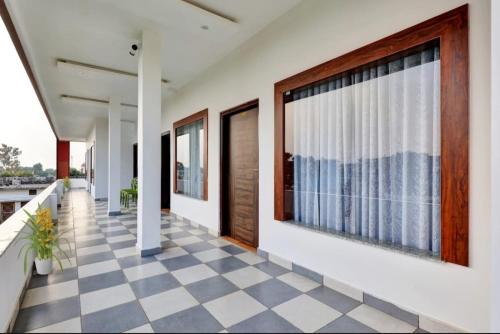 pasillo con suelo a cuadros y ventanas grandes en KG Resort en Haldwāni