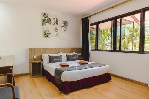 a bedroom with a bed and a large window at Pangkor Sandy Beach Resort in Pangkor
