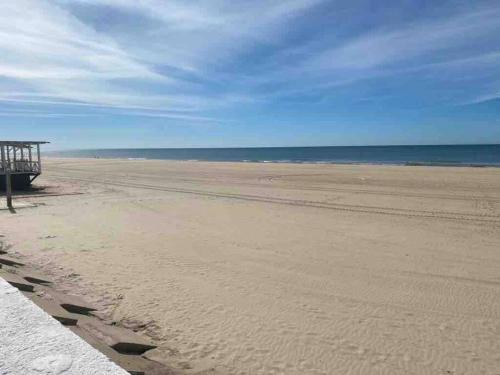 a sandy beach with a pier and the ocean at Beachfront 3 Bedroom Family Apartment in Matalascañas