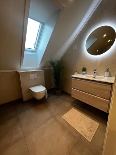 a bathroom with a sink and a toilet and a mirror at Nytt hus i rolig familiestrøk in Verdal