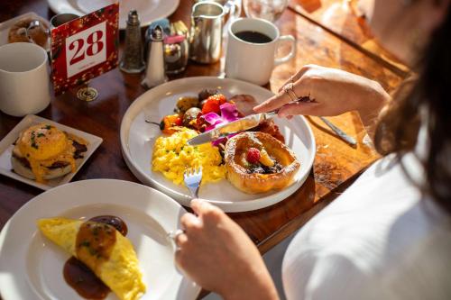a woman sitting at a table with plates of breakfast food at Hilton Anatole in Dallas