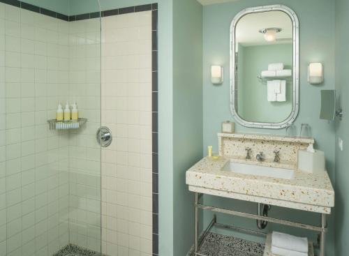 a bathroom with a sink and a shower at The Confidante Miami Beach, part of Hyatt in Miami Beach