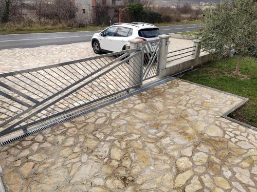 a white car parked on a bridge next to a road at Villa Hirundinidae in Gornji Muć