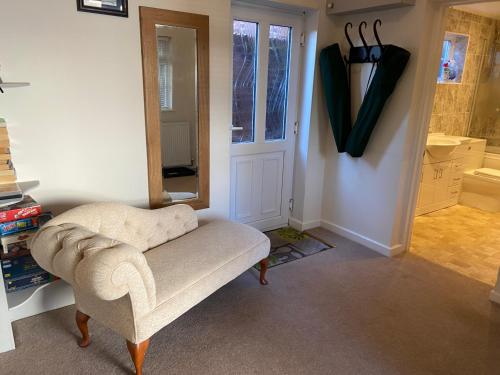 a living room with a chair and a door at The Bothy in Lyndhurst