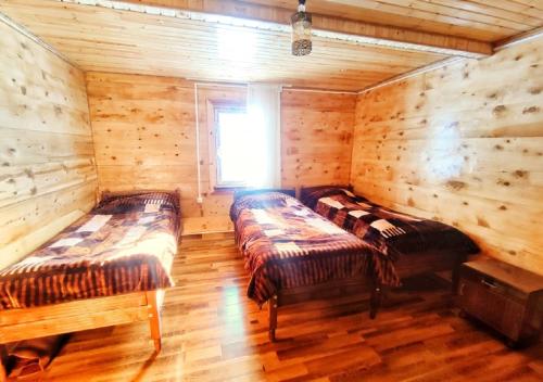 a room with two beds in a log cabin at Guest House Alaverdi in Khulo