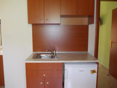 a small kitchen with a sink and a refrigerator at Oneiro Studios in Loutra Edipsou