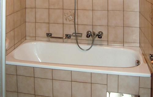 a bath tub with a shower in a tiled bathroom at Cozy Home In Kappl With House A Mountain View in Kappl