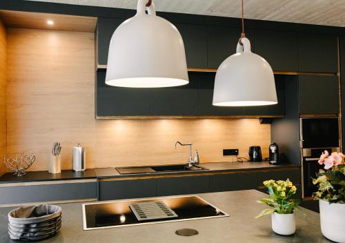 two white pendant lights hanging over a kitchen counter at Wellnesshotel Riedlberg in Drachselsried