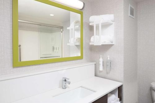 uma casa de banho com um lavatório branco e um espelho. em Hampton Inn Hornell em Hornell