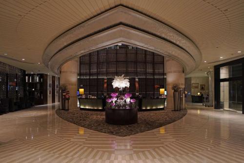 a lobby with a flower arrangement in the middle of a building at Hilton Bangkok Grande Asoke in Bangkok