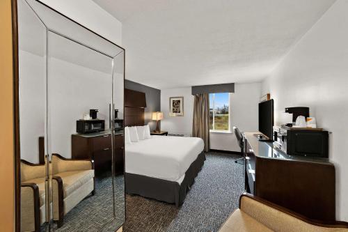 a hotel room with a bed and a mirror at Quality Inn & Suites in Caribou