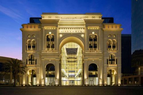 un gran edificio blanco con una fachada iluminada en The Hotel Galleria Jeddah, Curio Collection by Hilton, en Yeda