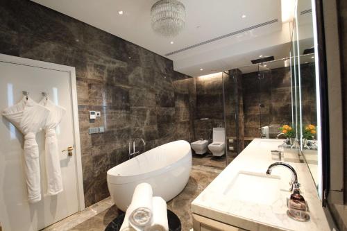 a bathroom with a large white tub and a sink at The Hotel Galleria Jeddah, Curio Collection by Hilton in Jeddah
