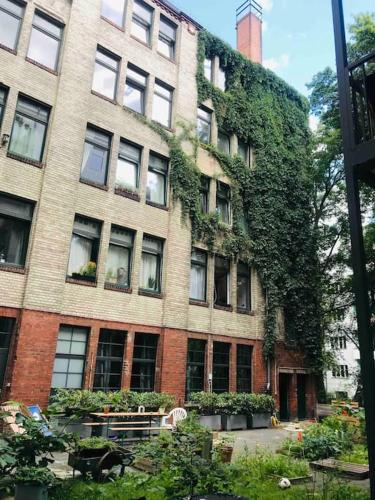 wysoki budynek z cegły, na którym rośnie bluszcz w obiekcie Small Cozy one room apartment in old Berlin factory w Berlinie